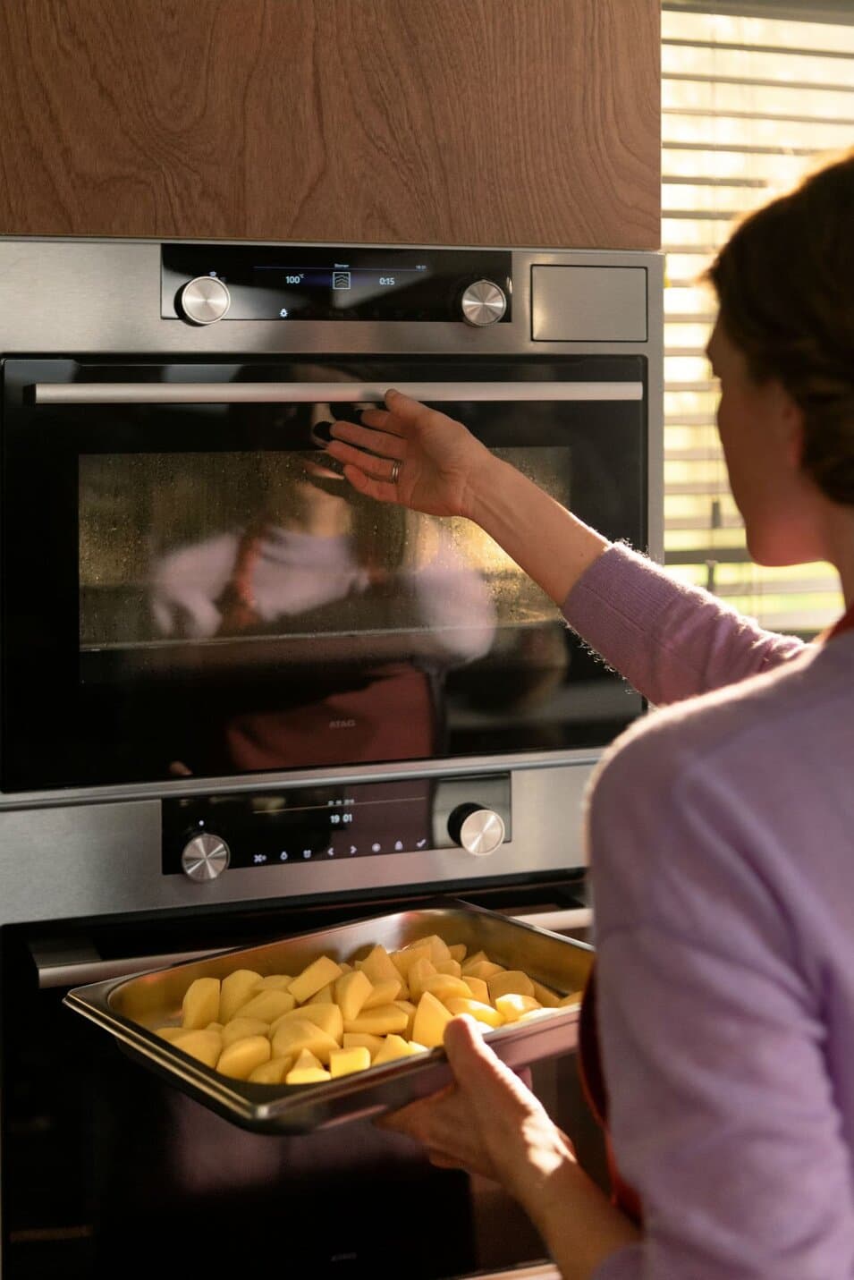 women put potatoes in oven