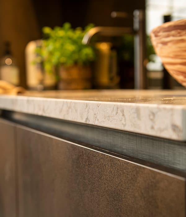 Detail-licht-caesarstone-werkblad-met-bronzen-fronten