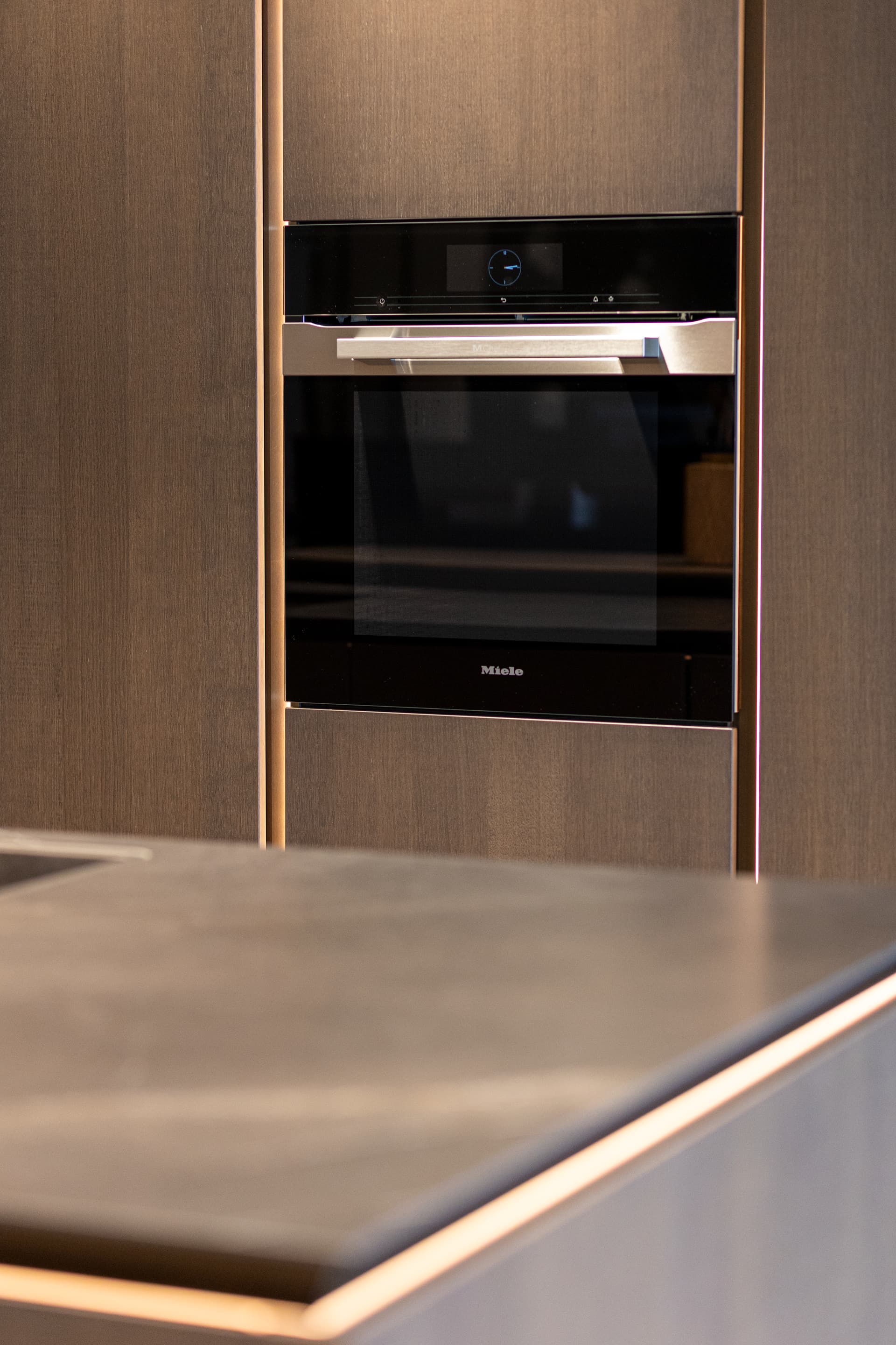 Detailshots MMK-92.png Hoge donker houte keukenkast met oven en een kookeiland