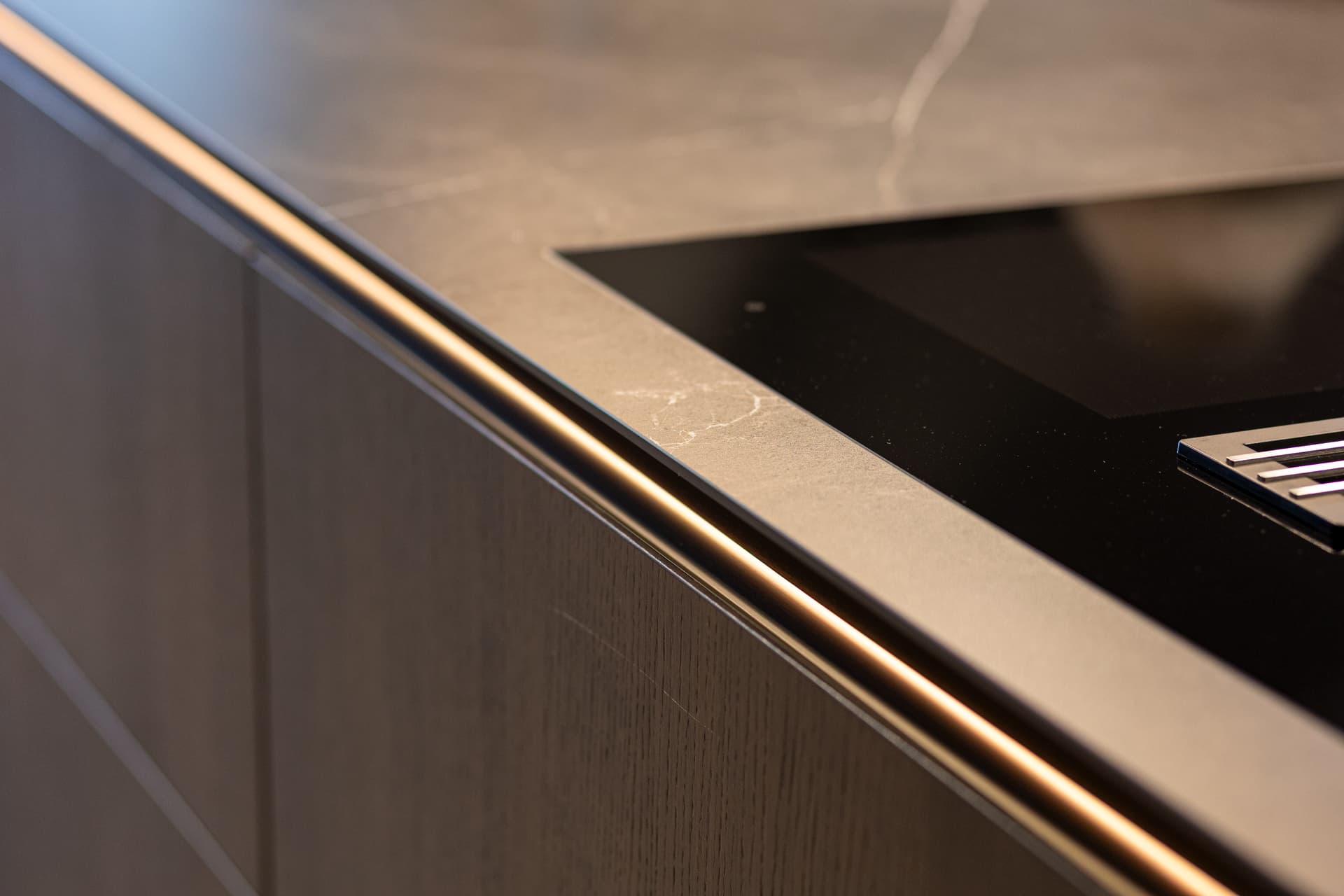 Detailshots MMK-97.png Close-up van zwart marmer werkblad op een donker houte keuken
