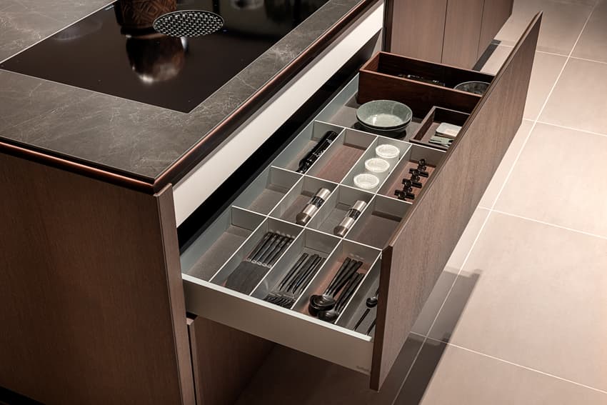 Lades.jpg Keukenla in donker houte keuken met een zwart marmer keukenblad