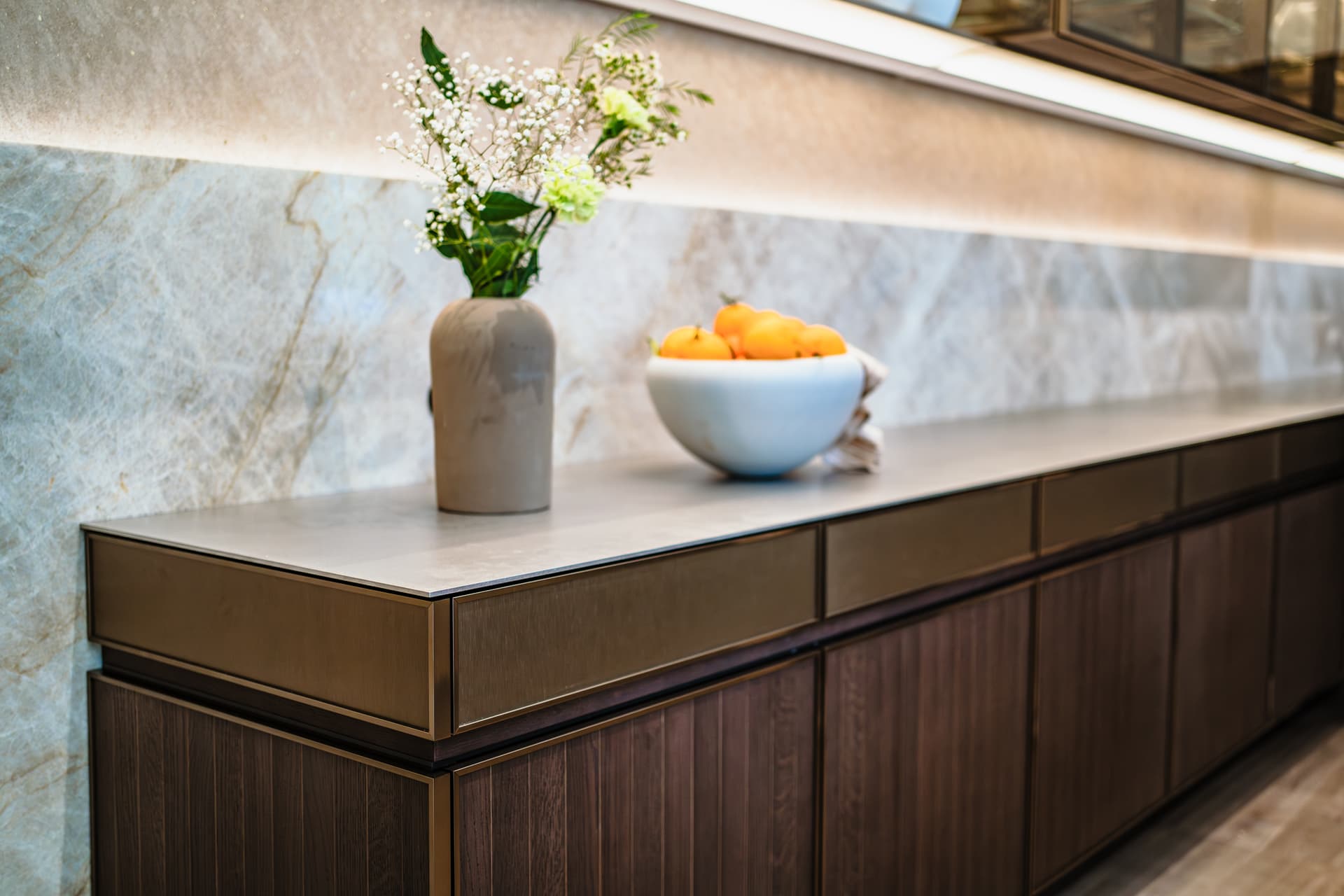 Donker houte keuken met een beige marmer achterwand