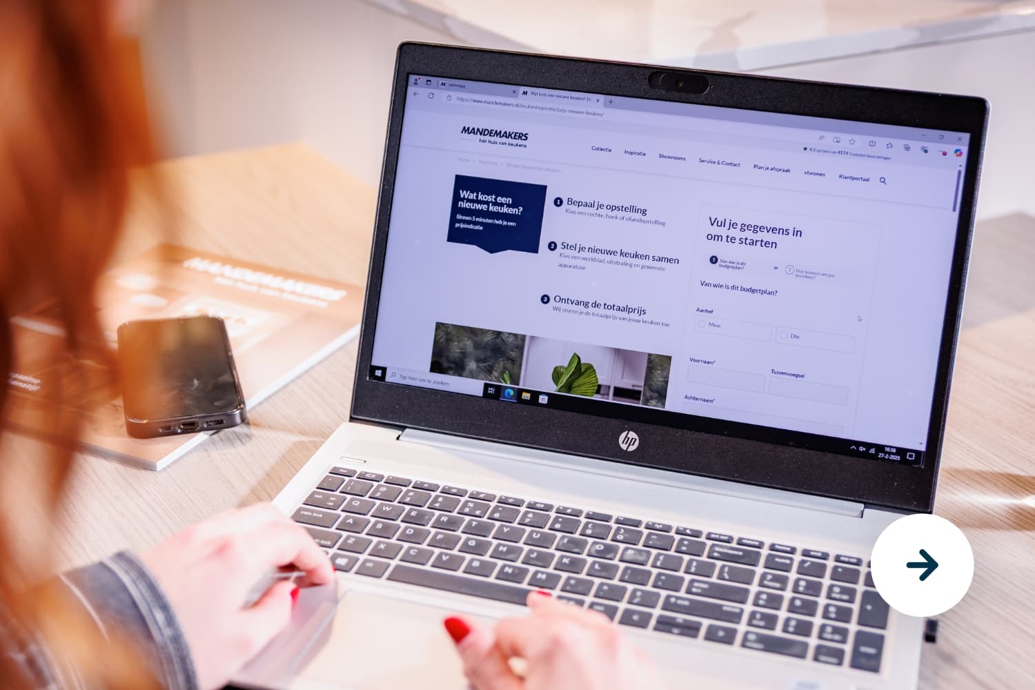 Wat kost een nieuwe keuken.jpg Vrouw die op haar laptop de kosten van een keuken aan het berekenen is met een tool
