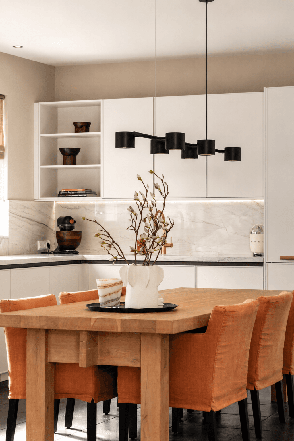 Houte eetkamertafel met 6 bruine stoelen in het midden van de keuken