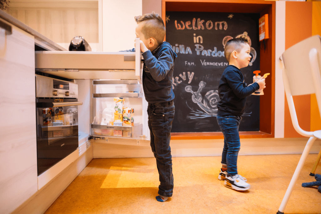 Twee kleine jongens aan het spelen in de keuken