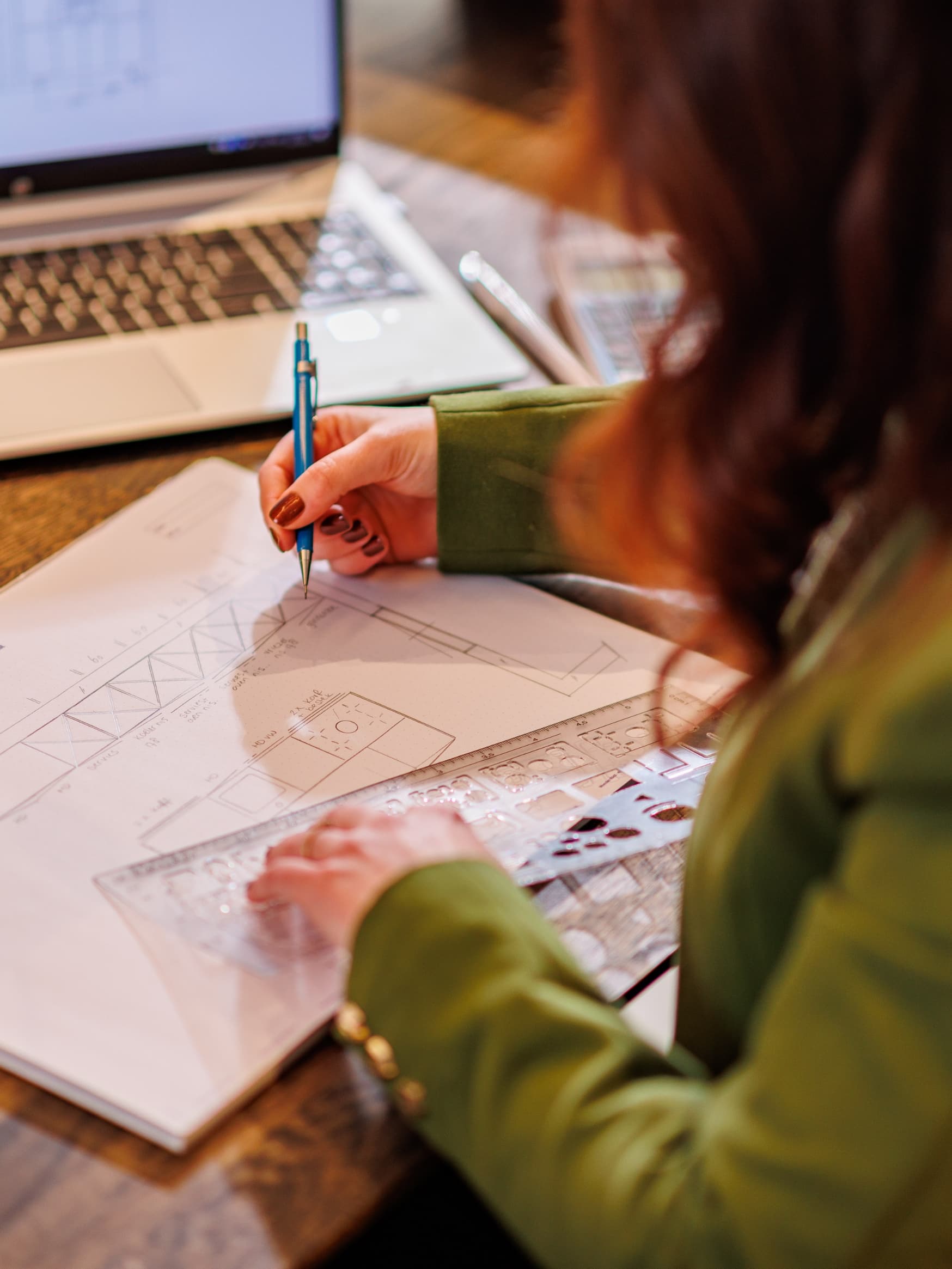Werken bij.jpg Foto van vrouw waar je over de schouder meekijkt naar hoe zij een werktekening van een keuken maakt