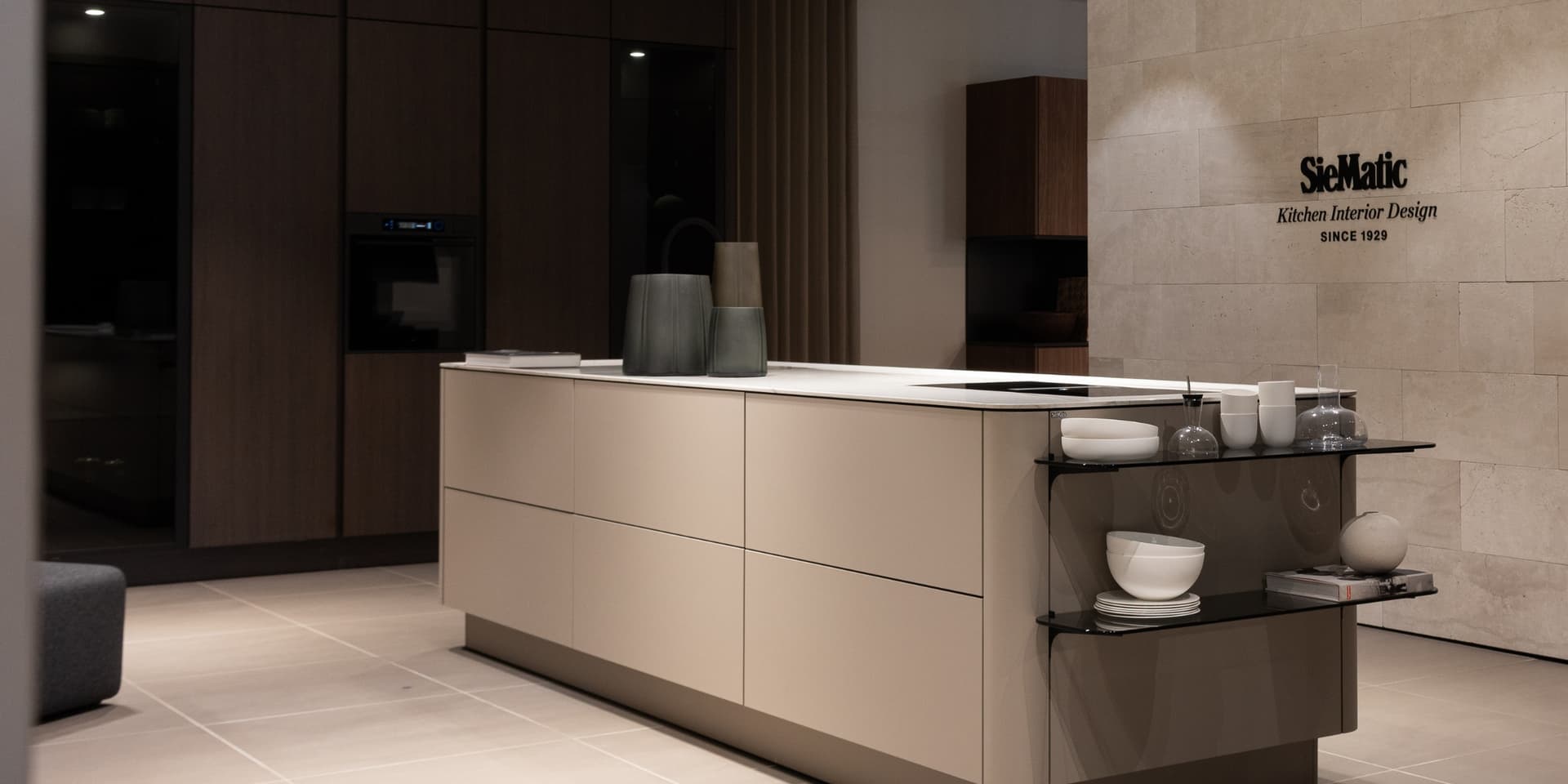 Showroom kookeiland zandkleurig met ronde vormen en een wit keukenblad